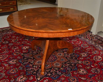 Lot 1663 - A Continental walnut loo table, the circular radially veneered top raised on a three-sided...