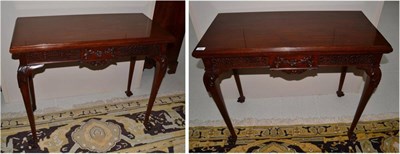 Lot 1665 - A pair of walnut fold-over card tables on carved claw feet