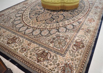 Lot 1680 - A good machine made artificial silk carpet of Oriental design, the deep indigo oval field with...