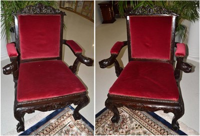 Lot 1682 - A pair of carved armchairs with dolphin hand grips and feet