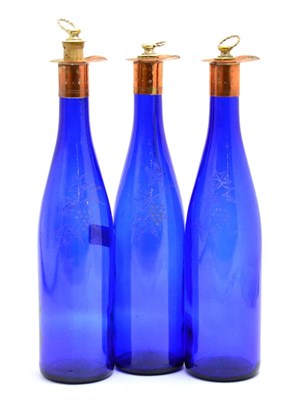 Lot 138 - Three blue glass decanters etched with leaves, height 32cm