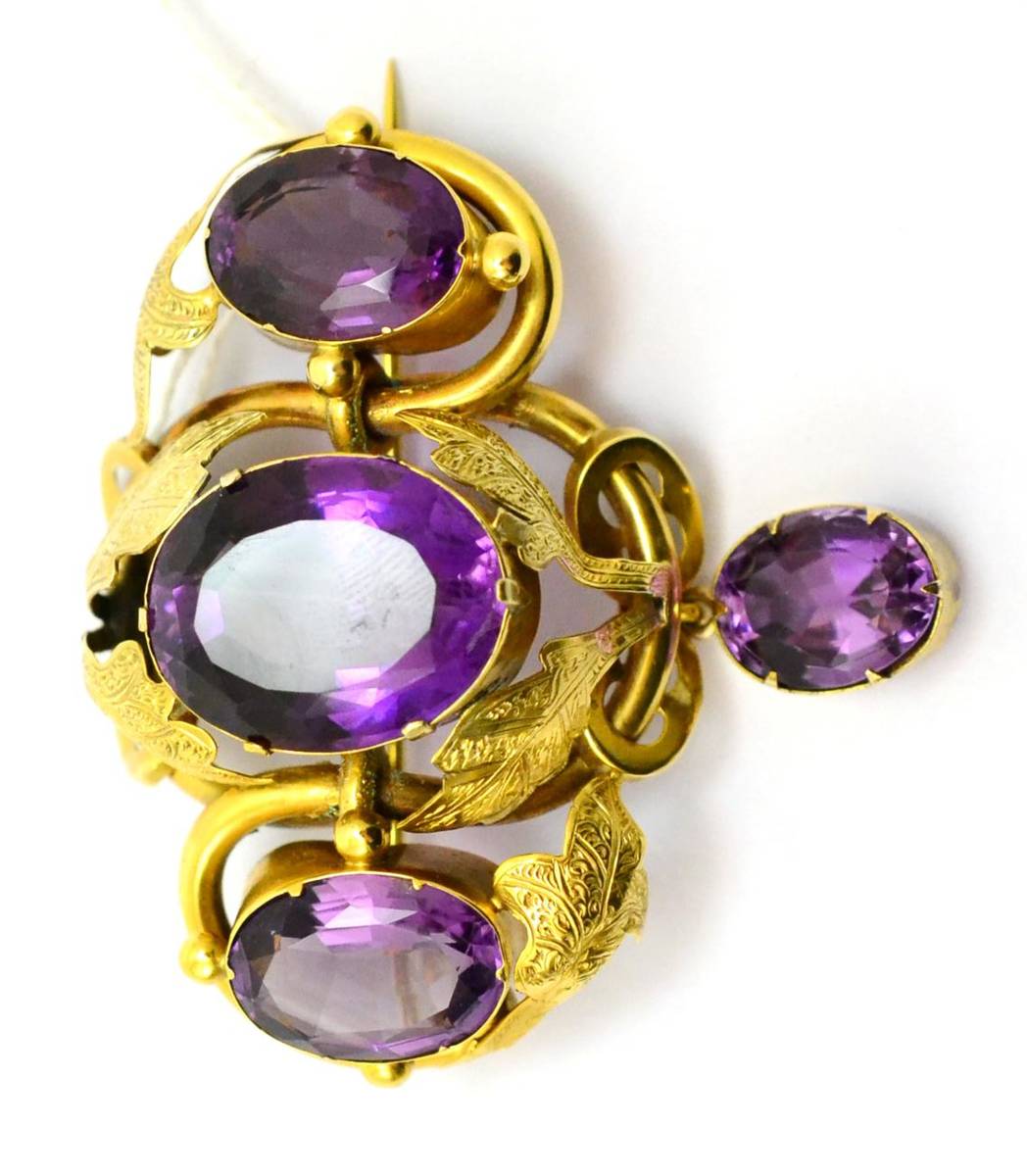 Lot 359 - # A Victorian brooch with three oval mixed cut amethysts within foliate decoration, and an amethyst