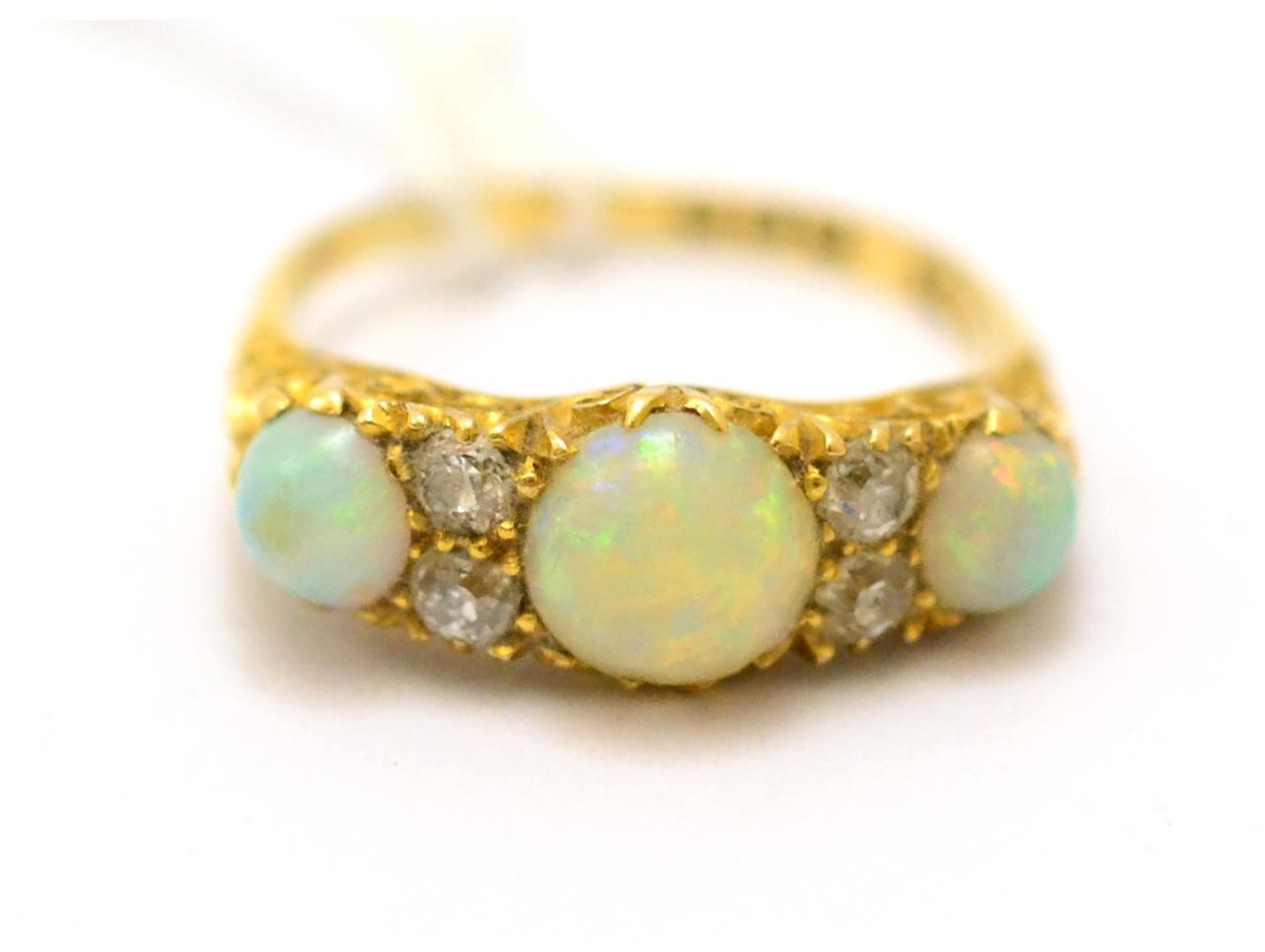 Lot 366 - A Victorian opal and diamond ring, three round cabochon opals alternate with pairs of old cut...