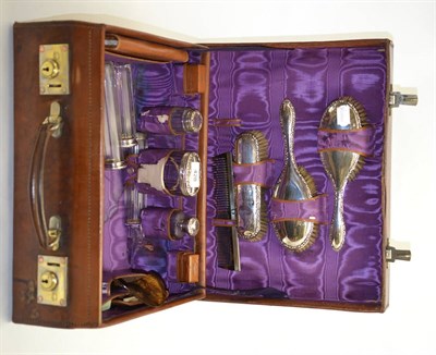 Lot 428 - A leather fitted vanity case with glass bottles and silver dressing table pieces