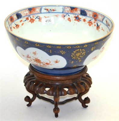 Lot 456 - A 19th century blue ground Imari decorated bowl, diameter 29.5cm, raised on a carved hardwood stand