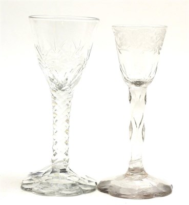 Lot 489 - A wine glass, circa 1780, the rounded funnel bowl engraved with a band of scrolling foliage on...