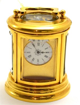 Lot 500 - A brass miniature carriage timepiece, circa 1900, oval shaped case with glazed bevelled panels...