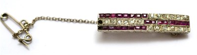 Lot 555 - An Art Deco ruby and diamond brooch, old cut diamonds and calibré cut rubies in white...