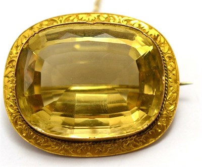 Lot 558 - A citrine brooch, the light greenish yellow cushion mixed cut citrine in a crimped setting within a