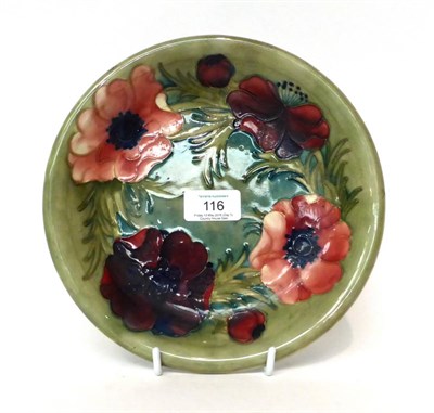 Lot 116 - * A Moorcroft pottery plate, decorated with anenomies on a green ground, signed, 22cm diameter