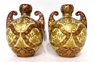 Lot 132 - * A pair of Royal Crown Derby cream and claret ground twin-handled vases, gilt with Persian...