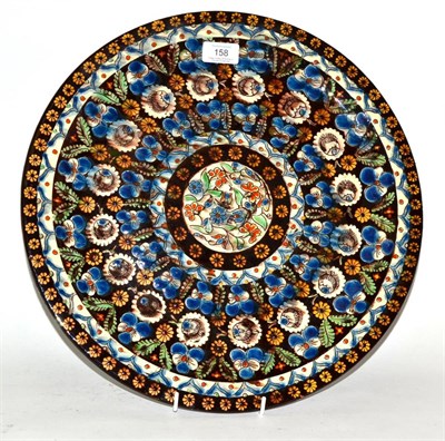 Lot 158 - * A late 19th century glazed slip ware charger, decorated with flowers, 41cm diameter