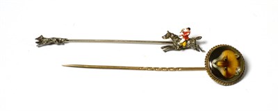 Lot 274 - A pin with diamond set running fox at one end and diamond and enamelled mounted huntsman at the...