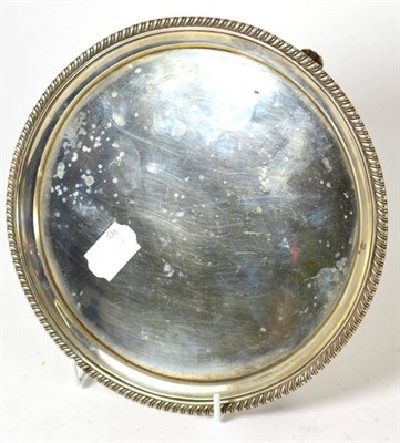 Lot 307 - A George III silver card tray, of dished circular form with gadrooned rim, raised on three...