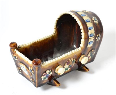 Lot 318 - A Measham ware cradle, monogrammed C N M and dated 1883