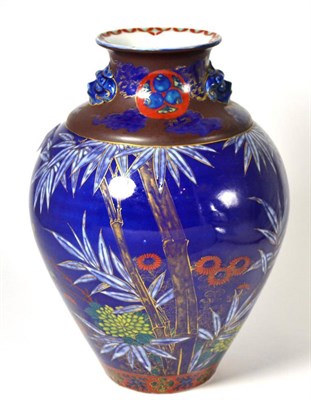 Lot 391 - A 19th century Japanese blue ground baluster jar with mask handles, painted with foliage, 31cm