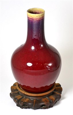 Lot 402 - A 19th century Chinese Sang de Boeuf bottle vase, 30cm high, hardwood stand