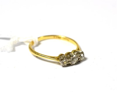 Lot 540 - A diamond three stone ring, three graduated diamonds in white claw settings on a yellow tapered...