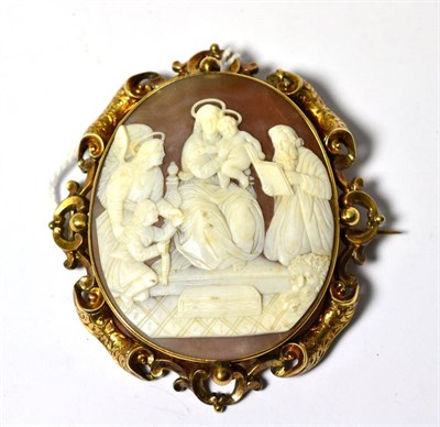 Lot 572 - An oval cameo brooch depicting a religious scene, in an engraved scrolling mount, measures 6.8cm by