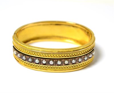 Lot 632 - A Victorian pearl set bangle, a single row of split pearls in squared settings, with heart...