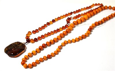 Lot 637 - An amber necklace and an amber pendant on necklace, knotted beads, the pendant carved with a floral