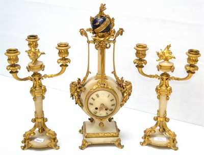 Lot 656 - A marble and gilt metal mounted striking mantel clock garniture, circa 1910, surmounted by a sphere