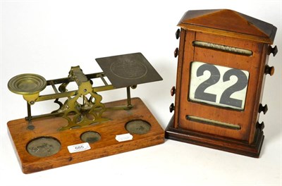 Lot 685 - ~ An early 20th century desk calendar and a set of late Victorian brass postal scales