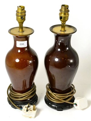 Lot 696 - A pair of brown glazed table lamps on hardwood stands, 30cm high