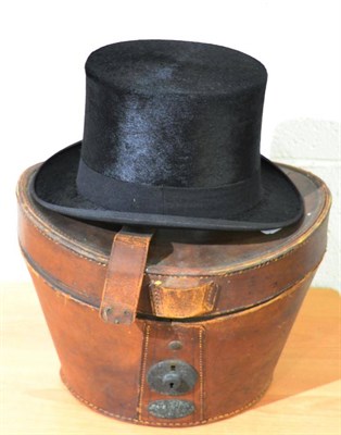 Lot 708 - A black silk top hat in a stitched leather case