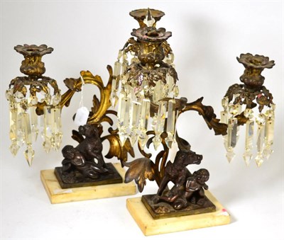 Lot 778 - A pair of French gilt bronze two-light candelabra, 19th century, the cast sconces hung with...