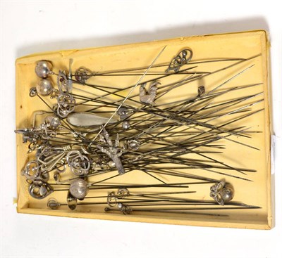 Lot 785 - A good collection of sixty silver and plated hat pins, surmounted with thistles, acorns, golf clubs