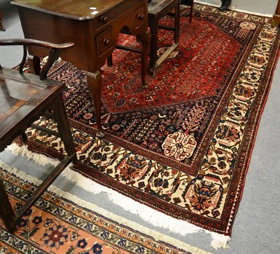 Lot 1221 - Abudeh carpet, South Persia, the deep red lozenge field with columns of stylised plants around...