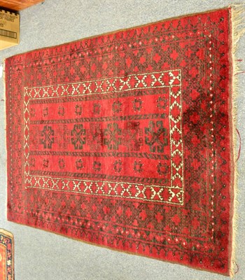 Lot 1263 - Turkmen rug, North Afghanistan, the claret field with a column of hooked devices enclosed by...