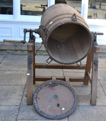 Lot 1291 - + A large staved oak barrel on stand, a Victorian oil cake breaker stamped H Bamford & Sons, a...