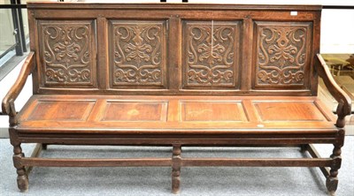 Lot 1309 - ~ An 18th century carved oak settle, with fielded back support