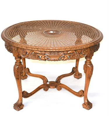 Lot 1331 - *A early 20th century carved walnut circular centre table with circular cane and glass top