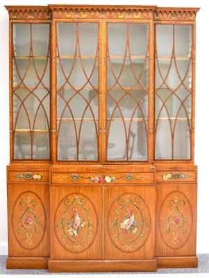 Lot 1368 - A satinwood breakfront bookcase, painted with polychrome garlands and swags, with an arcaded...