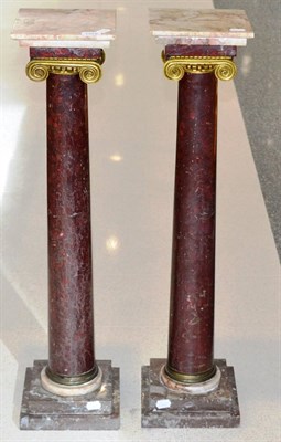 Lot 1372 - A pair of rose marble columns with gilt metal scroll caps