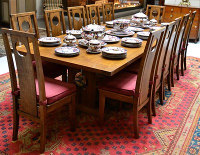 Lot 1378 - A reproduction oak dining table of recent date with fourteen matching chairs