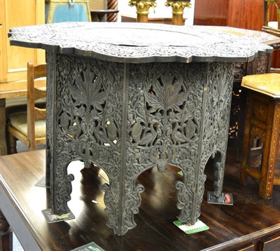 Lot 1489 - A large carved Indian table with pierced brass centre