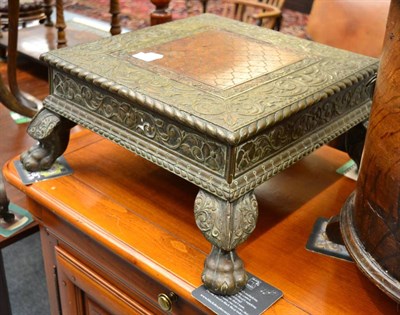 Lot 1495 - An Anglo Indian embossed brass low stand on four ball and claw feet