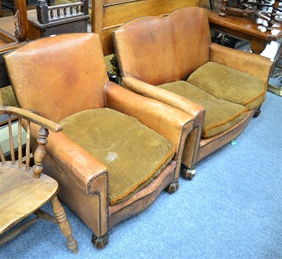 Lot 1518 - + A 1920s/1930s two seater sofa covered in original closed nail leather and matching armchair