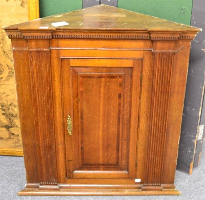 Lot 1538 - A George III oak corner cupboard