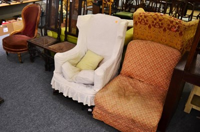 Lot 1576 - ^ A wingback armchair with loose cover, together with a late Victorian nursing chair with later...