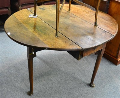 Lot 1704 - * An 18th century oak drop leaf table on pad feet