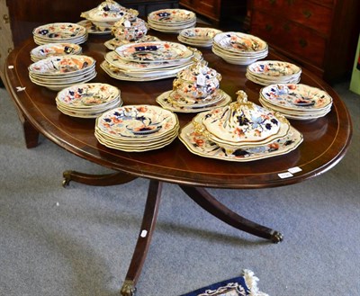 Lot 1736 - A 19th century mahogany dining table of Regency style, the oval crossbanded top on a gun barrel...