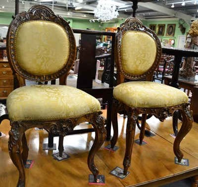 Lot 1761 - * A pair of late Victorian carved walnut salon chairs upholstered in yellow silk fabric