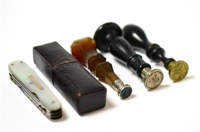 Lot 7 - A 19th century agate hand seal, two ebonised wood examples, and a mother of pearl combination...