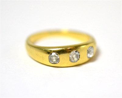 Lot 17 - A diamond three stone ring, the old cut diamonds drill set into the yellow plain polished...