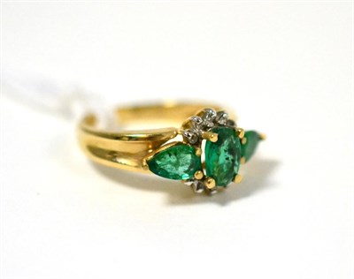 Lot 29 - An emerald and diamond ring, an oval cut emerald within a part border of diamonds, with a pear...
